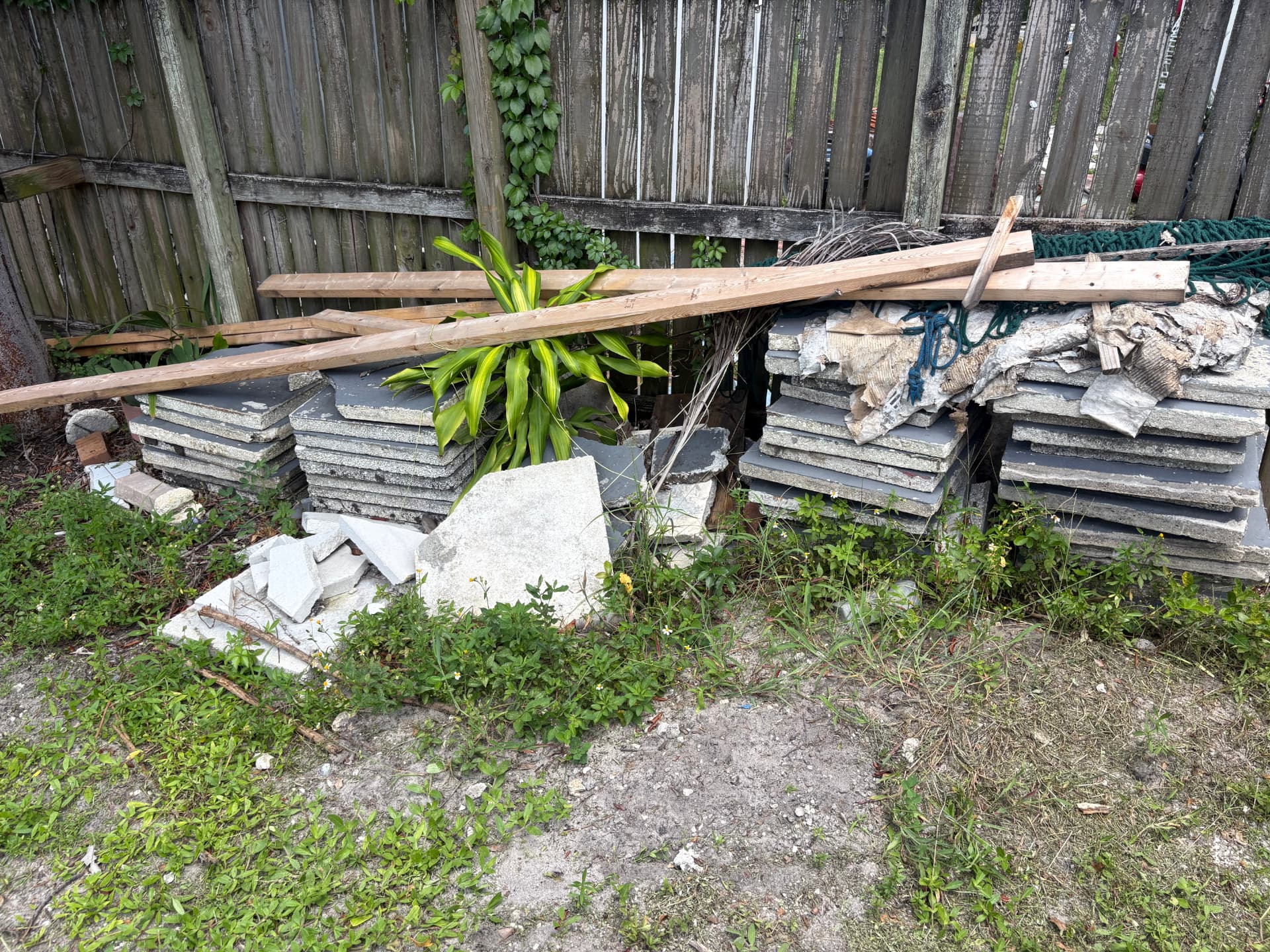 Stacked concrete pavers, lumber and yard debris ready for hauling
